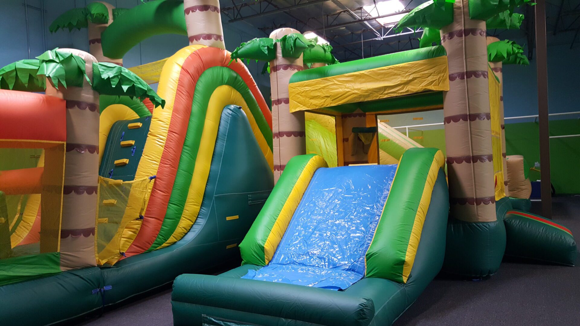 A bunch of inflated slides in the middle of an indoor playground.