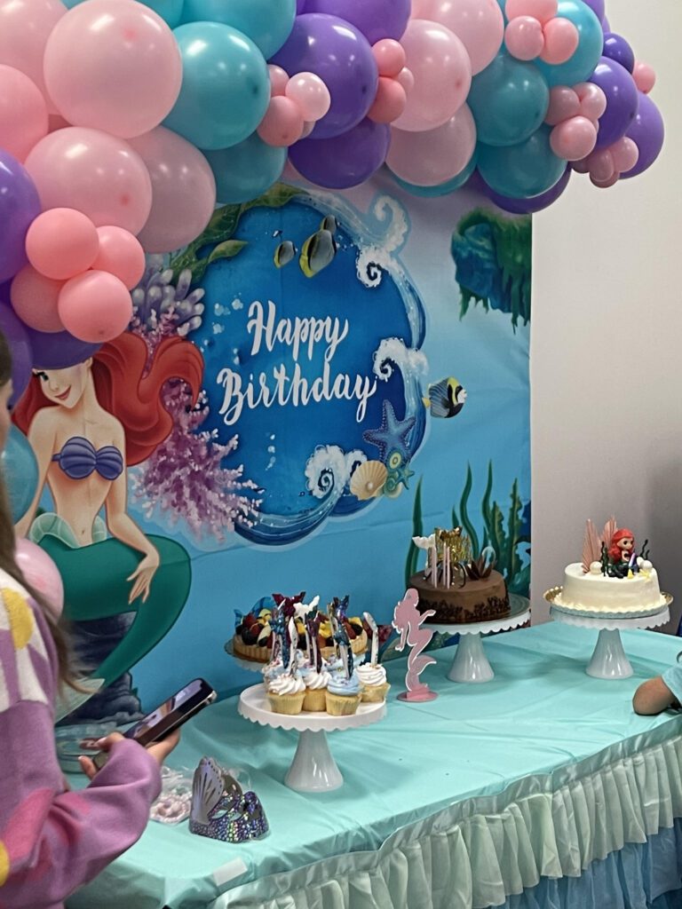 A birthday party with balloons and cake on the table